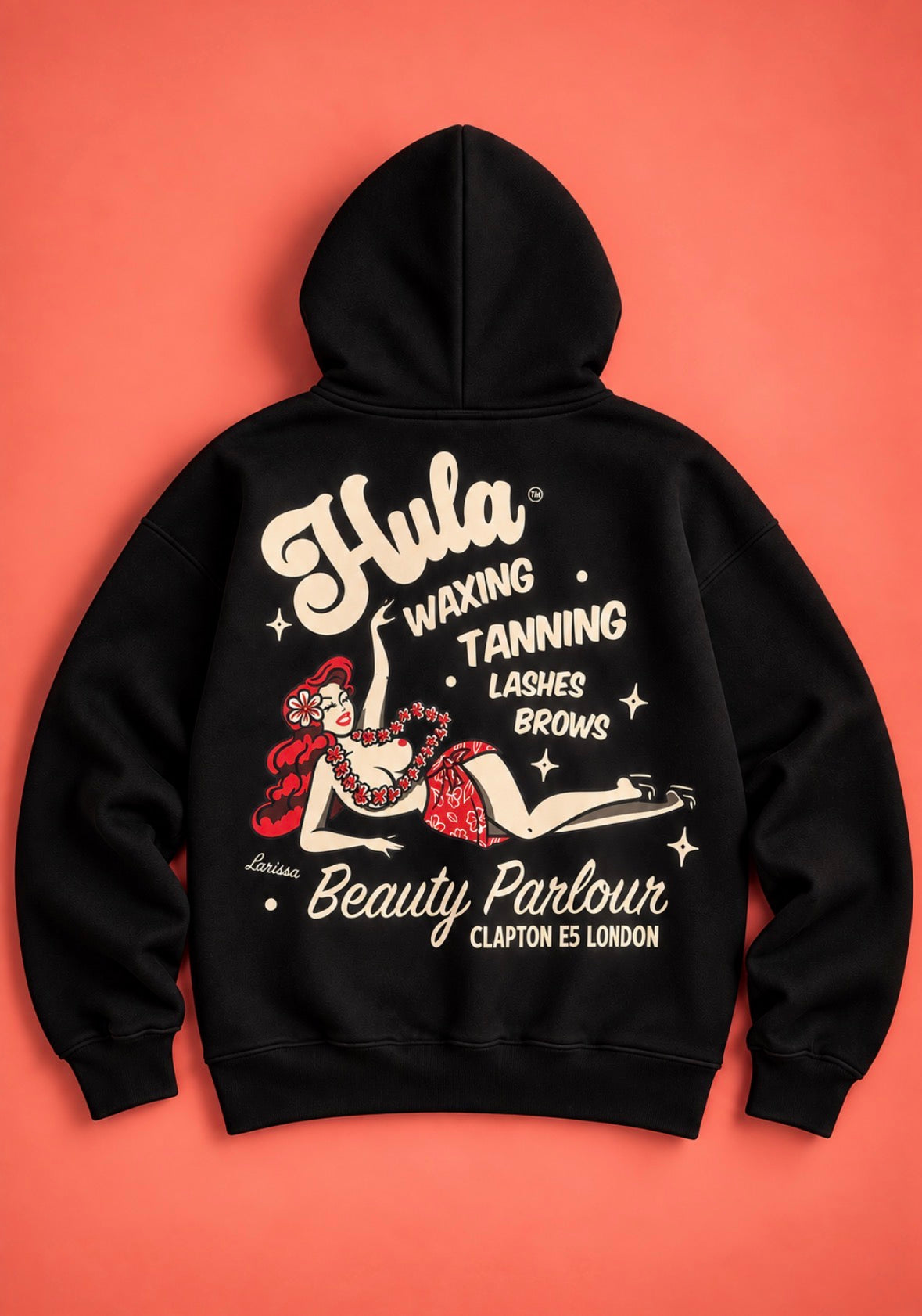 A black hoodie shown from the back, featuring a large vintage-style graphic print in cream and red. The graphic includes the text 'Hula Waxing Tanning Lashes Brows Beauty Parlour' and an illustration of a pin-up-style woman.