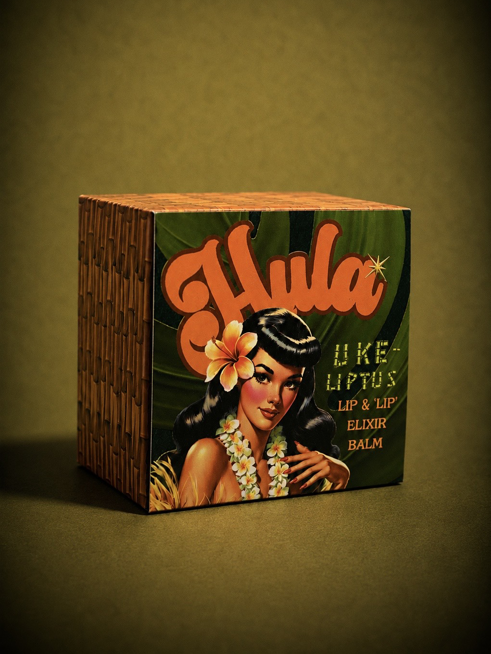 A square product box for Hula Uke-Lyptus Lip & Nip Balm, featuring a retro Hawaiian pin-up illustration with a flower in her hair and bold orange lettering, set against a dark olive background.