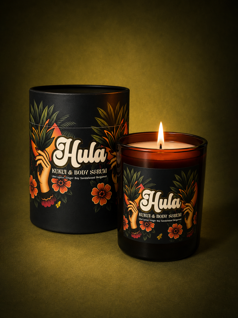 A lit amber glass jar candle labelled Hula Kukui & Body Serum sits in front of its matching black cylindrical packaging on a dark olive background.